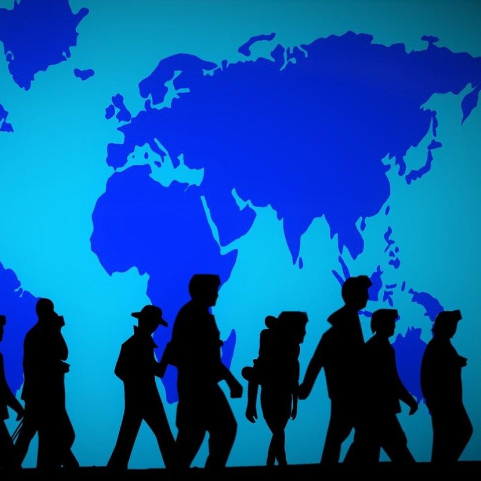 A group of people silhouetted against a blue map of the world