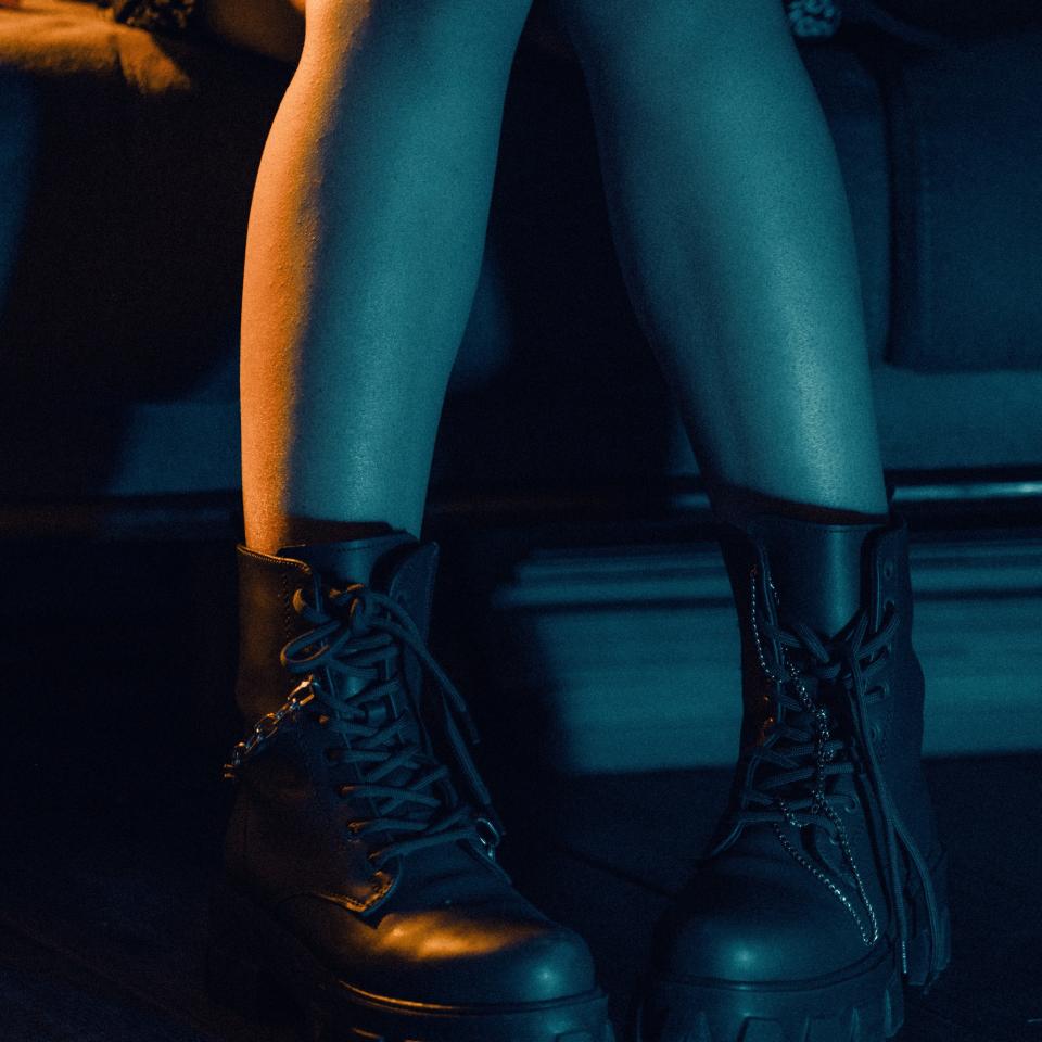 Close up of a woman's legs wearing black ankle boots