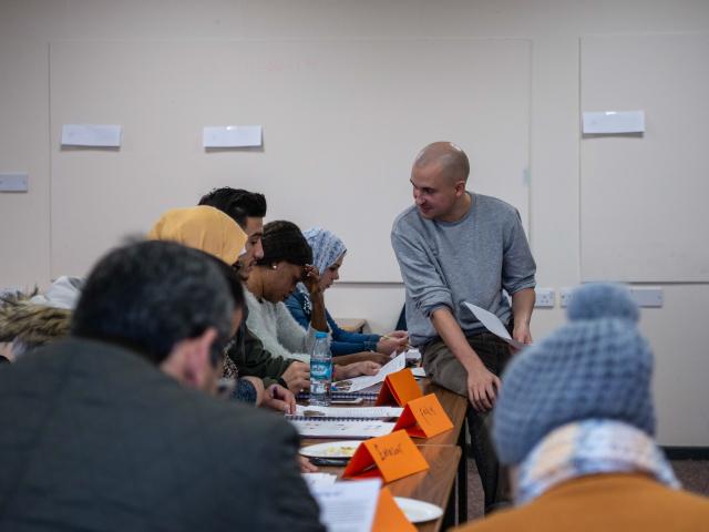 A man teaching a class of adults