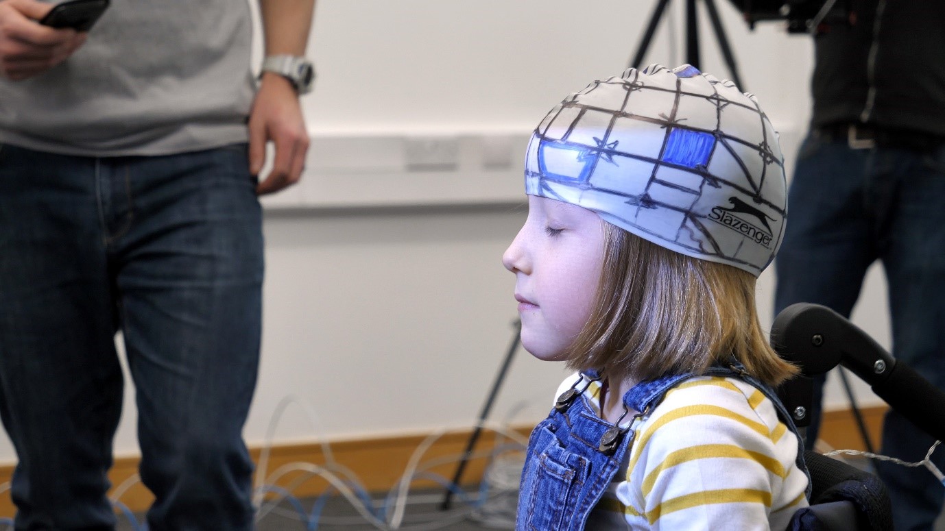 A young girl wearing a helmet with sensors