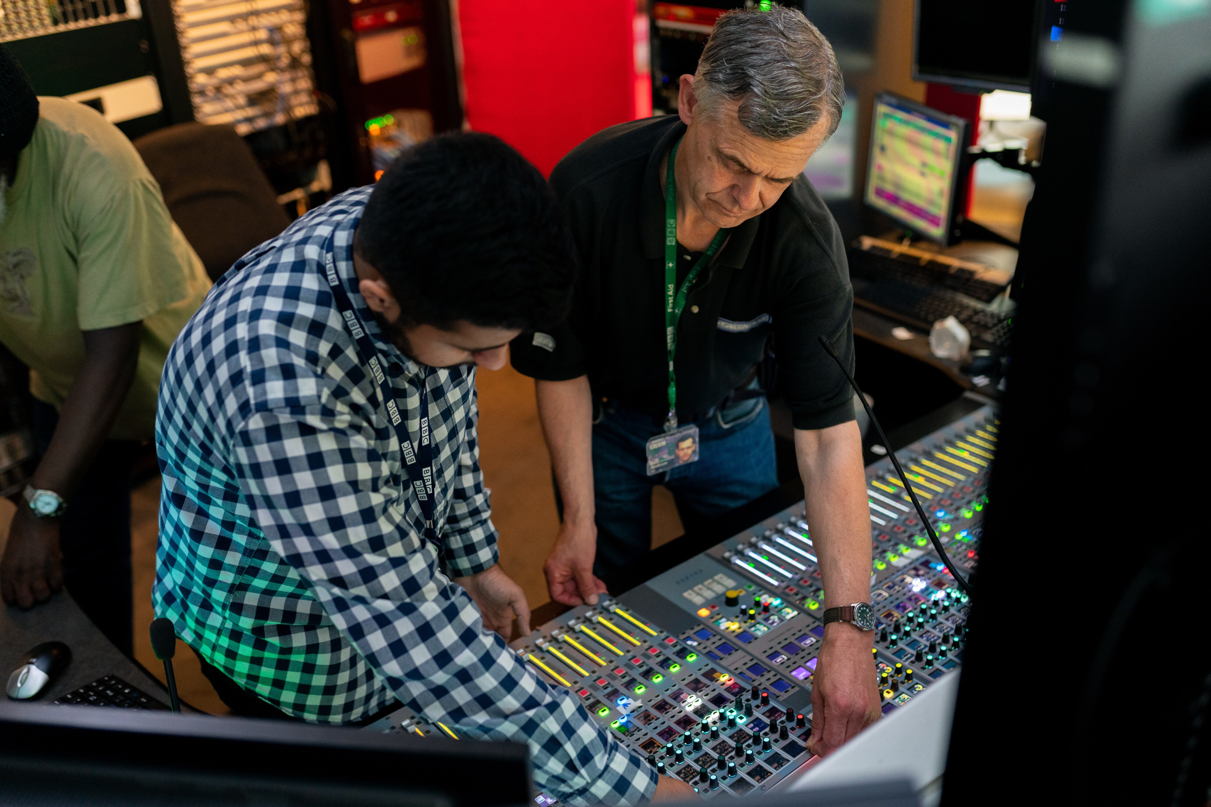 Two men working on a sound mixing desk in a studio