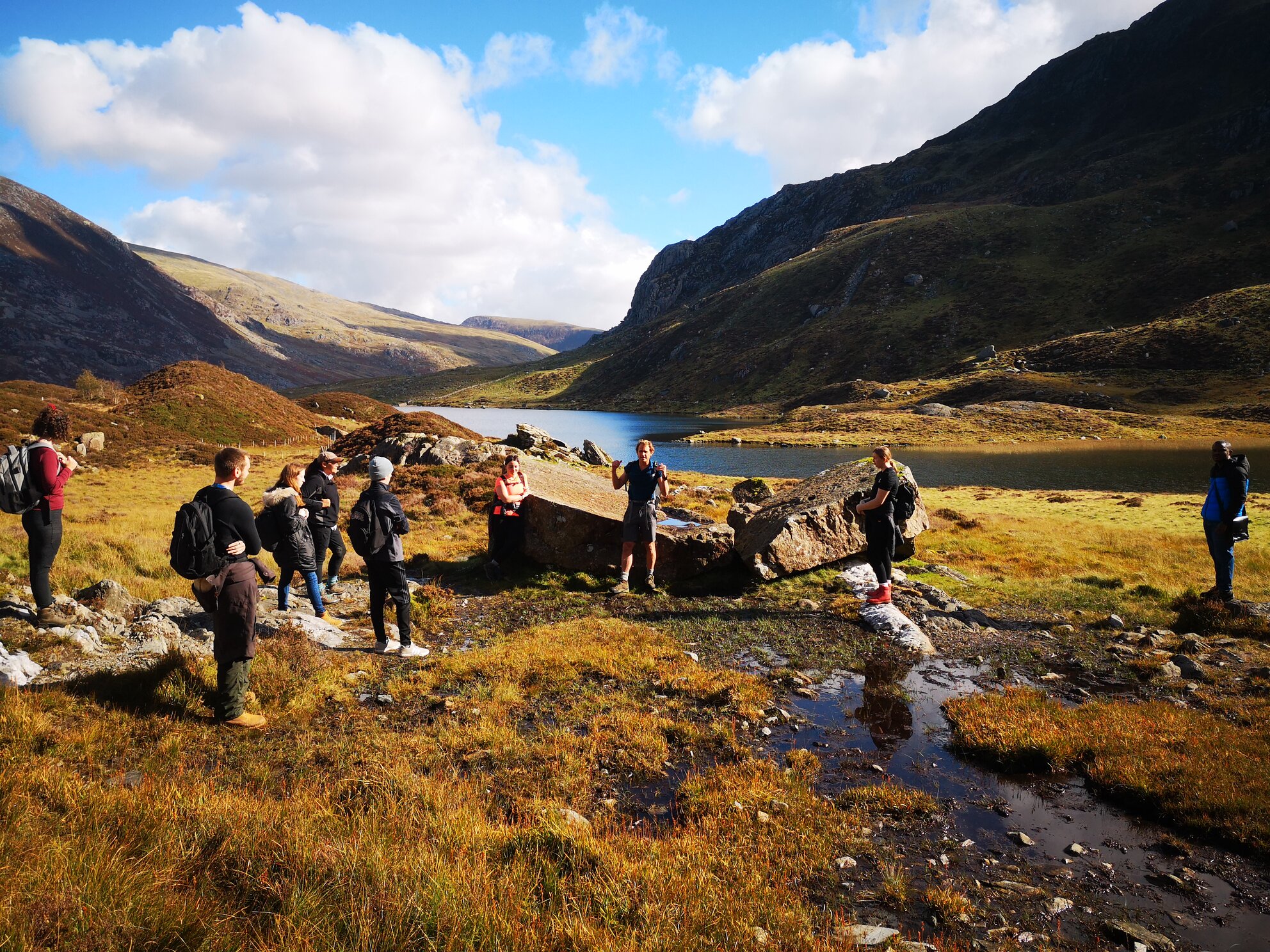 A group of students on a field trip in the mountains near a river