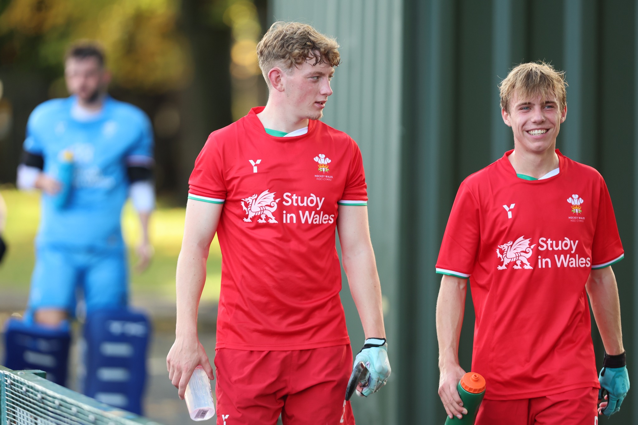 Two Hockey Wales players wearing the shirt featuring the Study in Wales logo