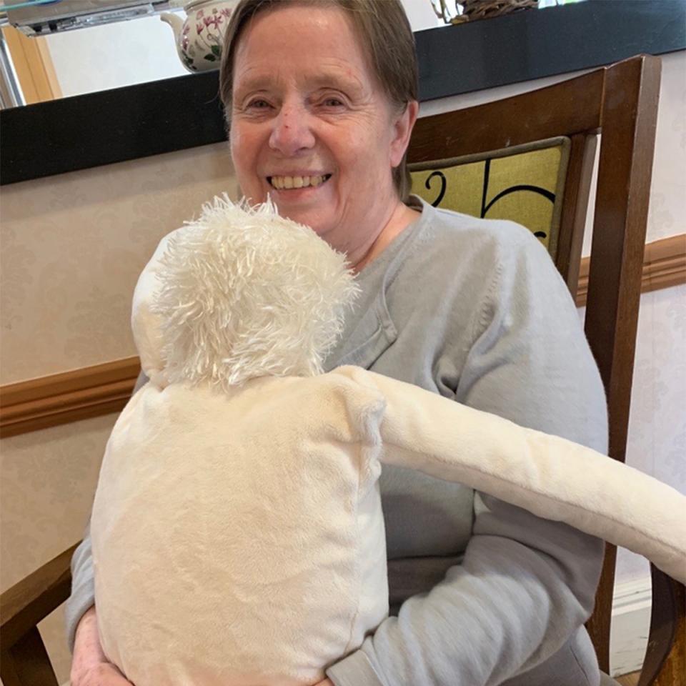 Lady sitting in chair hugging a cuddly toy