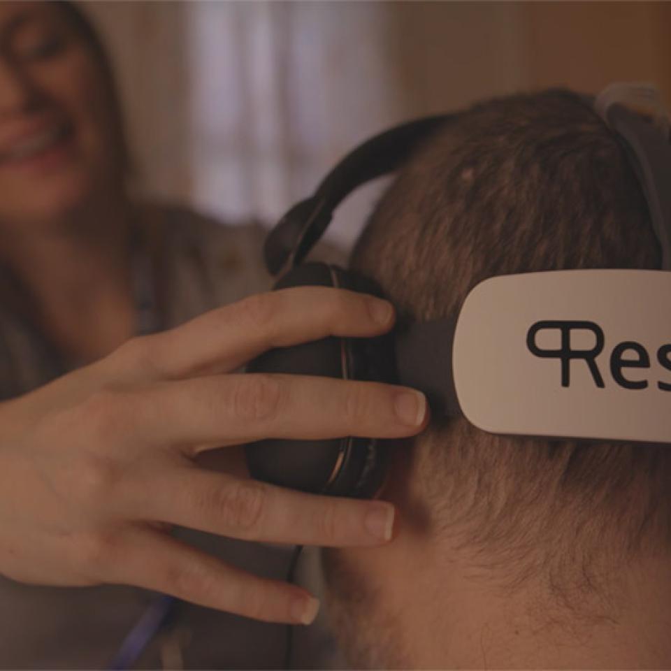 Woman placing a VR headset on a man