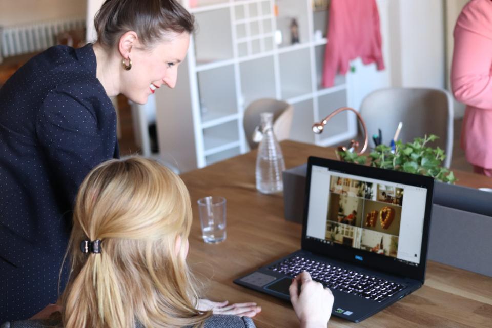 Two women smiling and looking at a computer