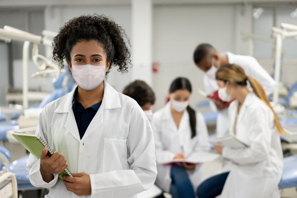 Group of students wearing white lab coats and face masks