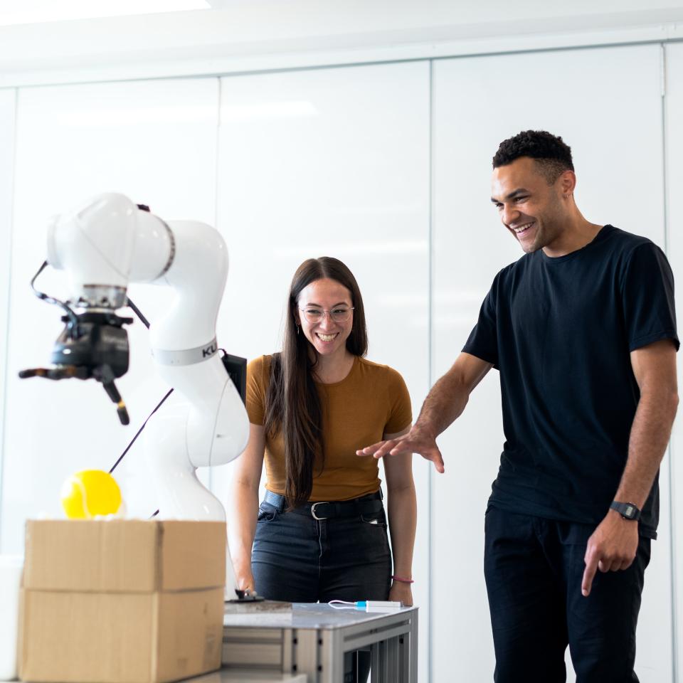 1 male and 1 female engineer working with medical robotic equipment