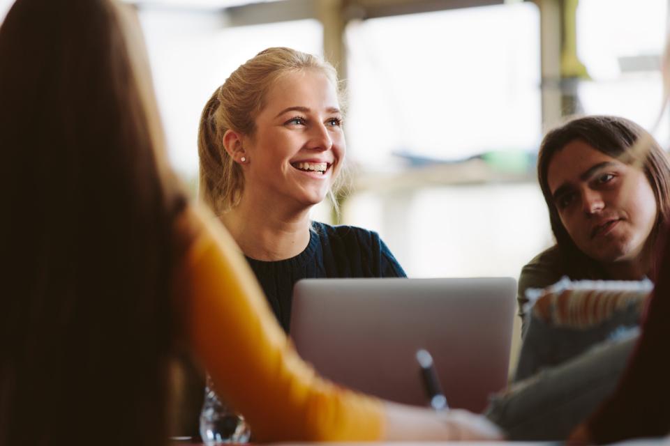 Female student sitting at a table on a laptop