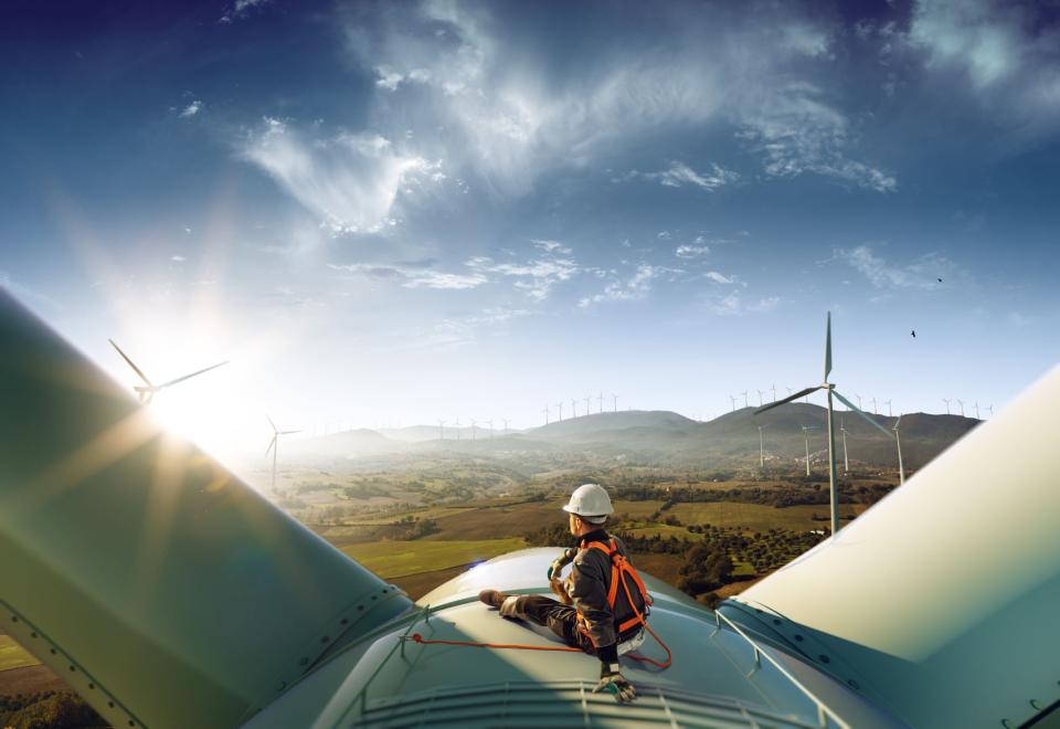 Man sitting on a wind turbine looking over the countryside