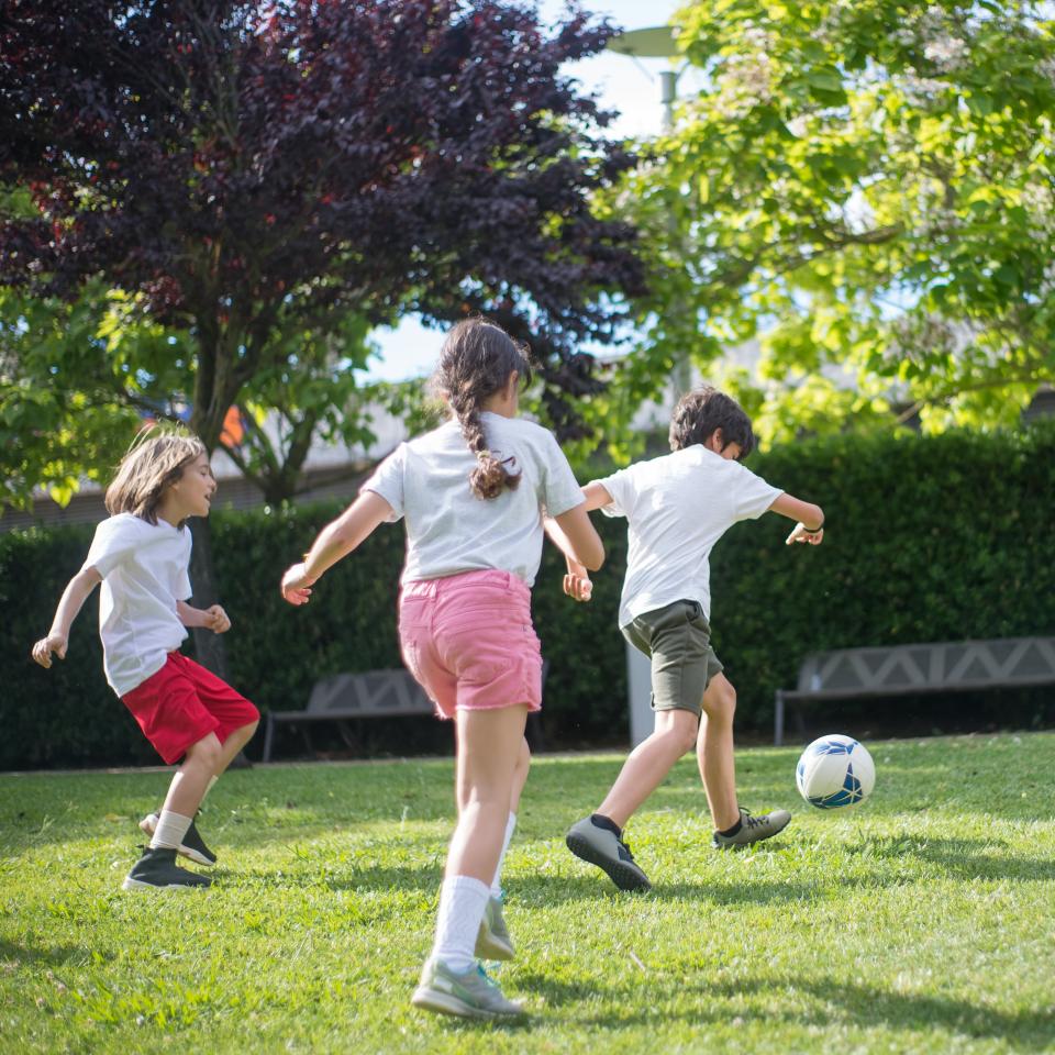 A group of children playing football outdoors