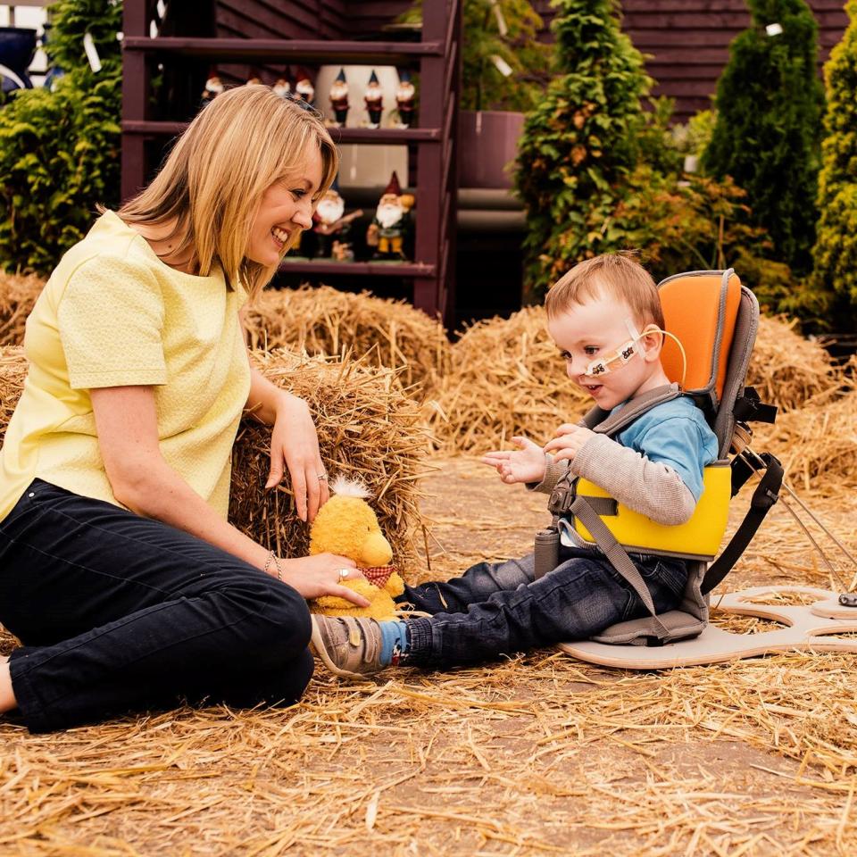 A young boy using the goto seat pictured with a woman