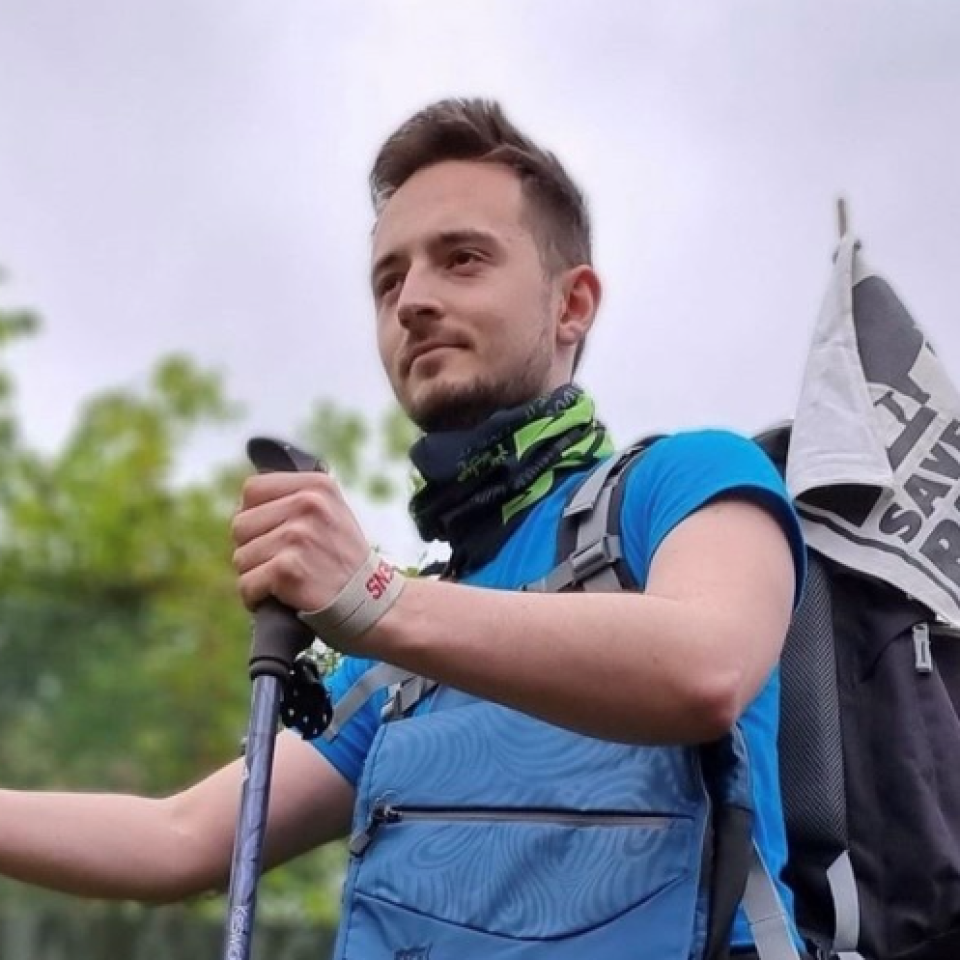 A photo of Ryan Eddowes hiking with walking poles