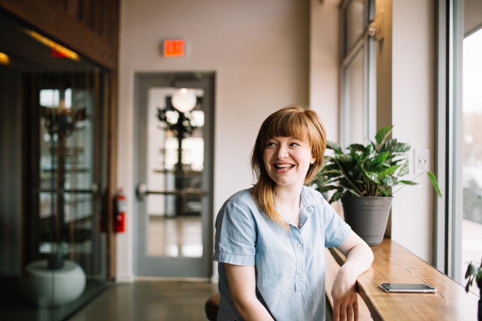 Smiling woman sitting at a desk by a window