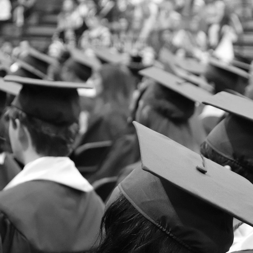 black and white photo of a crowd of people in graduation caps and gowns