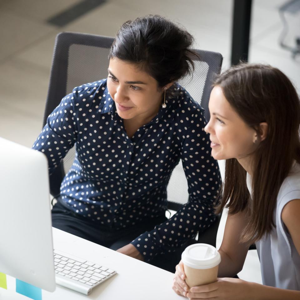 Two women working at a desktop computer