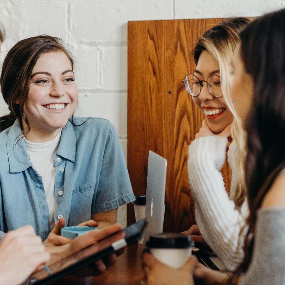 A group of young people sitting around a table talking