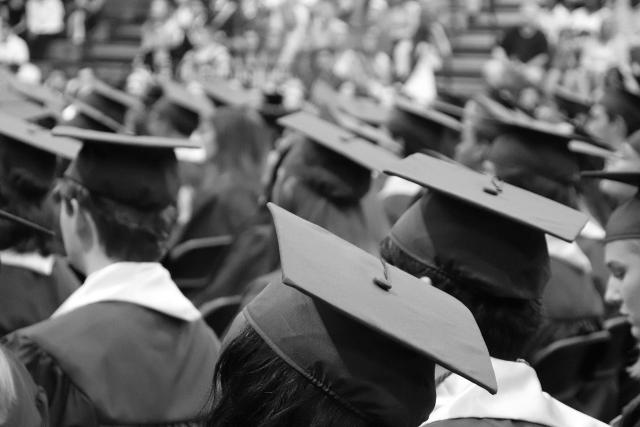 Black and white photo of students in graduation caps and gowns