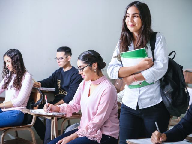 smiling woman walking through a class of students