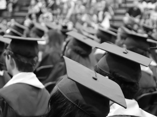 black and white photo of a crowd of people in graduation caps and gowns