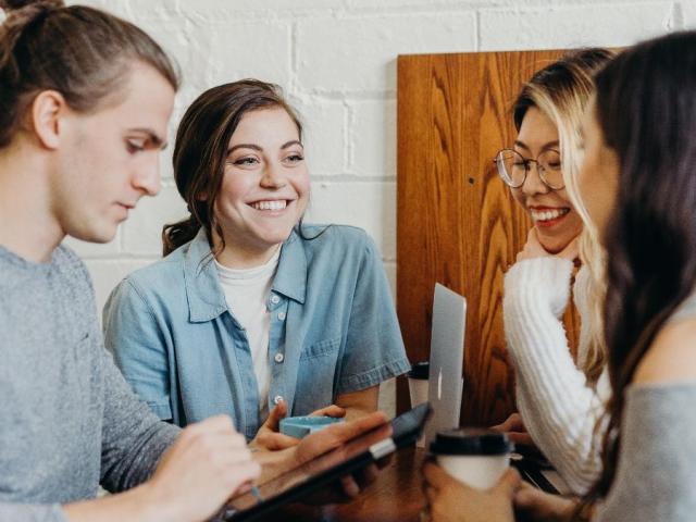 A group of young people sitting around a table talking